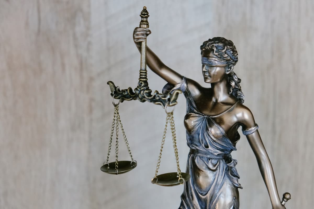 A bronze statue of Lady Justice, blindfolded and holding a set of balance scales